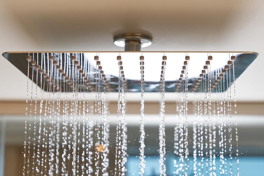 Rain shower head turned on in the shower.