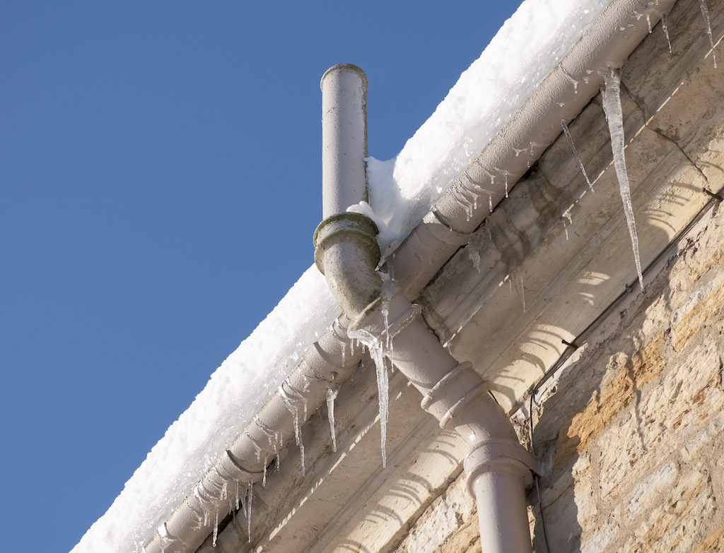 Frozen pipe on the side of an older home. Winter Plumbing Tips. 