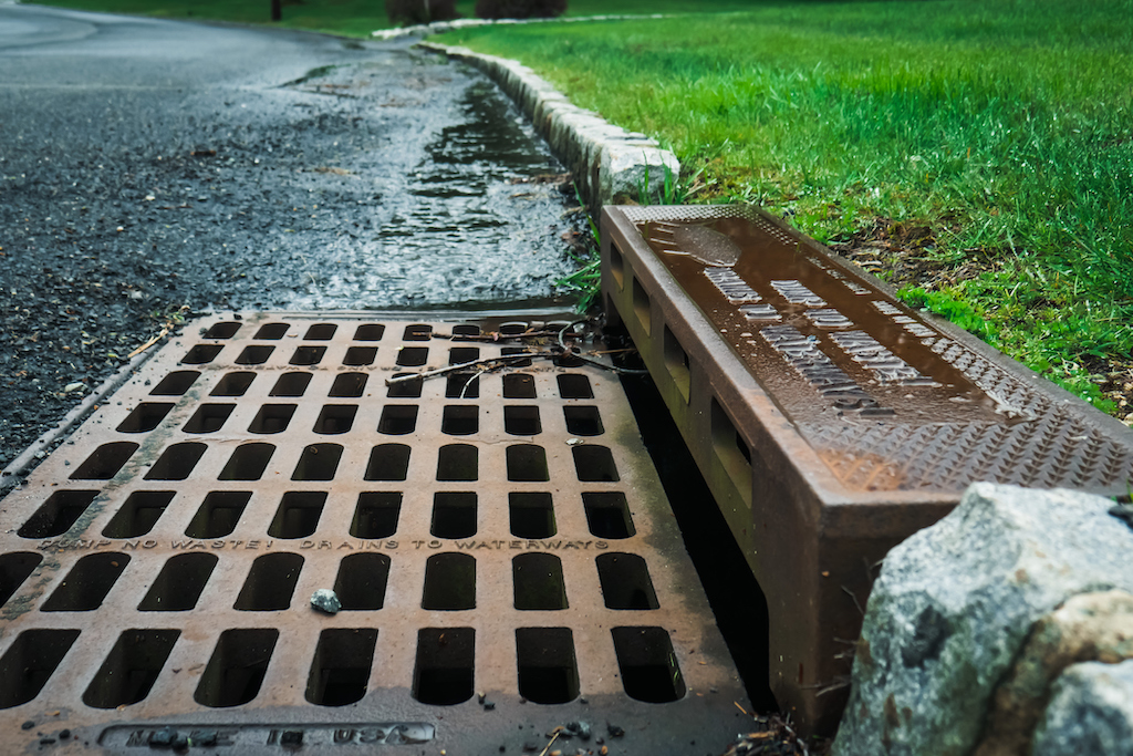 Storm Drain Cleaning service, storm drain on rainy day. 