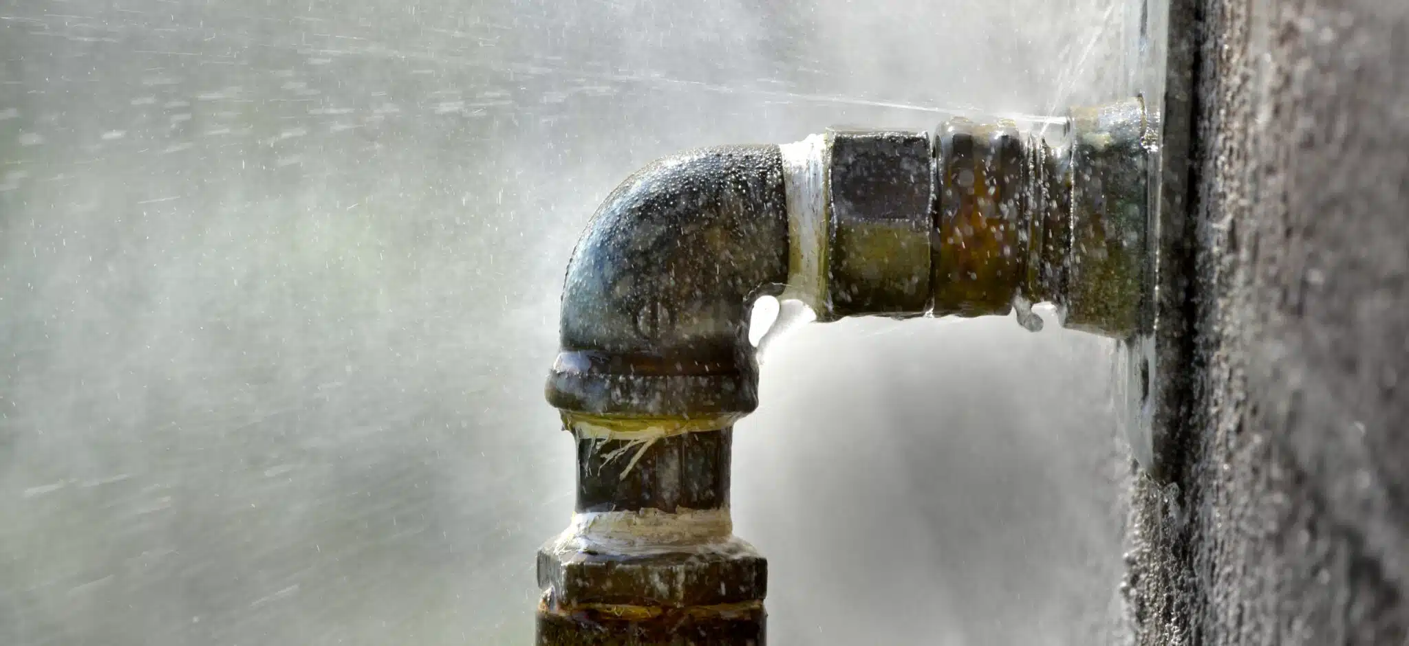 Old rusty pipe with leak and water spraying out, Pipe Vibration.