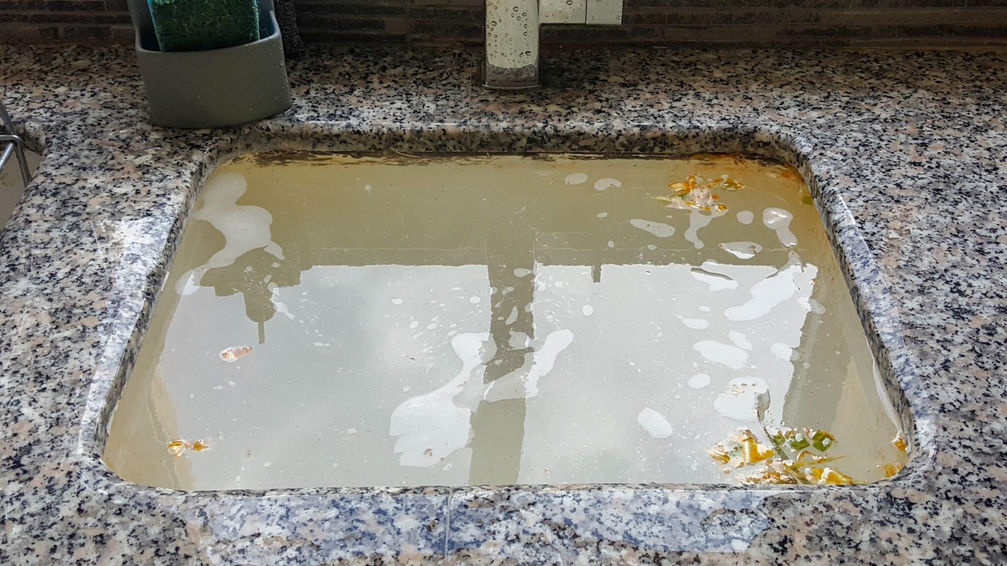 A clogged kitchen drain is one of the common signs your garbage disposal needs attention.